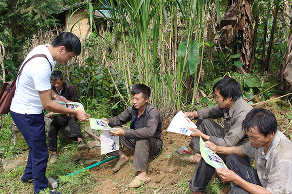 Cán bộ Trung tâm Dân số - KHHGĐ huyện Mèo Vạc phát tờ rơi tuyên truyền về Chính sách dân số