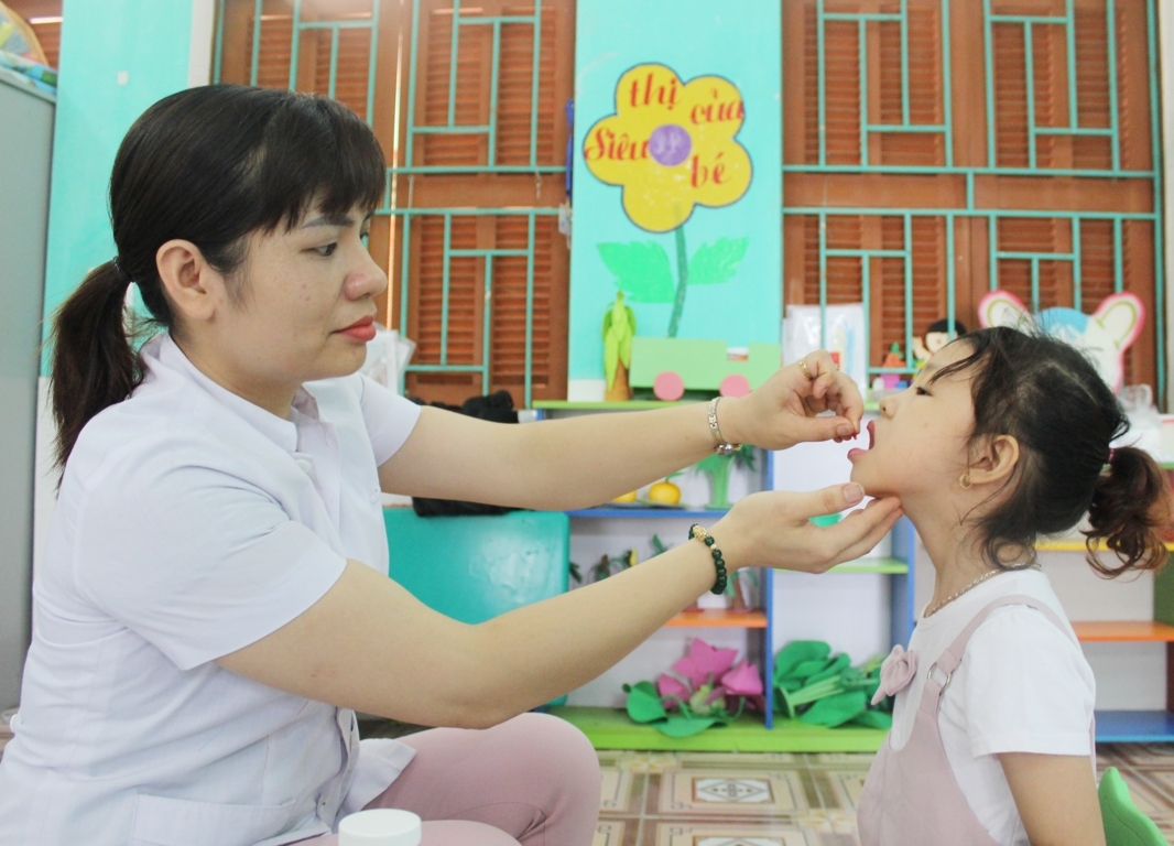 Cán bộ Trạm Y tế phường Nguyễn Trãi cho trẻ uống Vitamin A trong chiến dịch