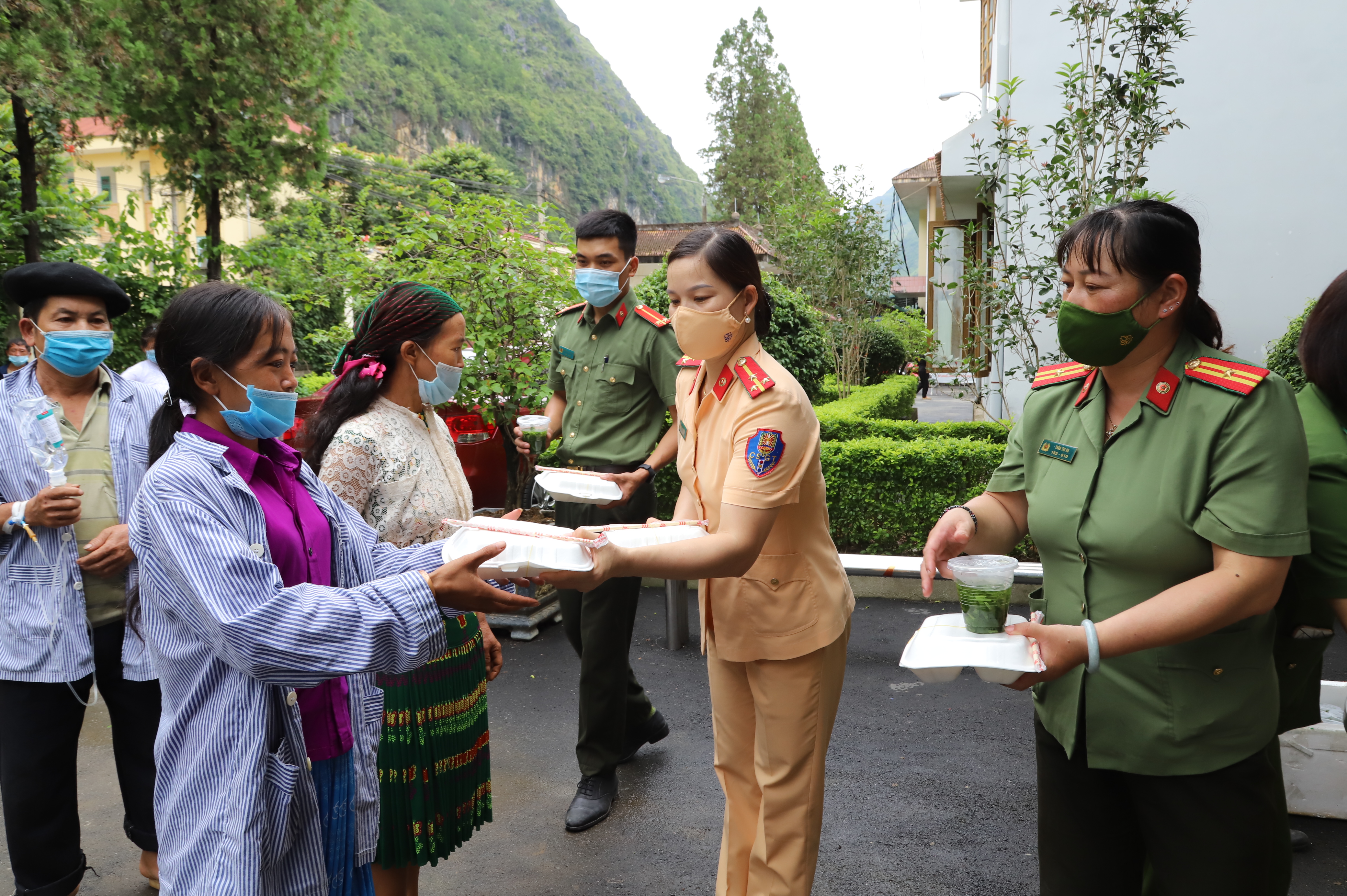 Cán bộ, chiến sĩ Công an huyện Mèo Vạc trao các suất cơm miễn phí cho người bệnh đang điều trị tại bệnh viện đa khoa huyện