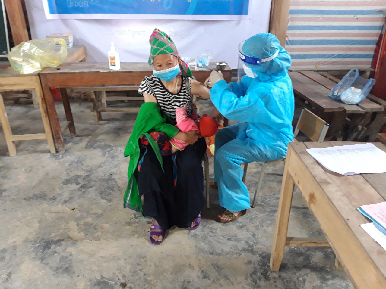 Chị Hoàng Thị Kim Thu tiêm vắc xin phòng Covid-19 cho người dân tại
 thôn Nắm Ngà xã Cốc Rế, huyện Xín Mần