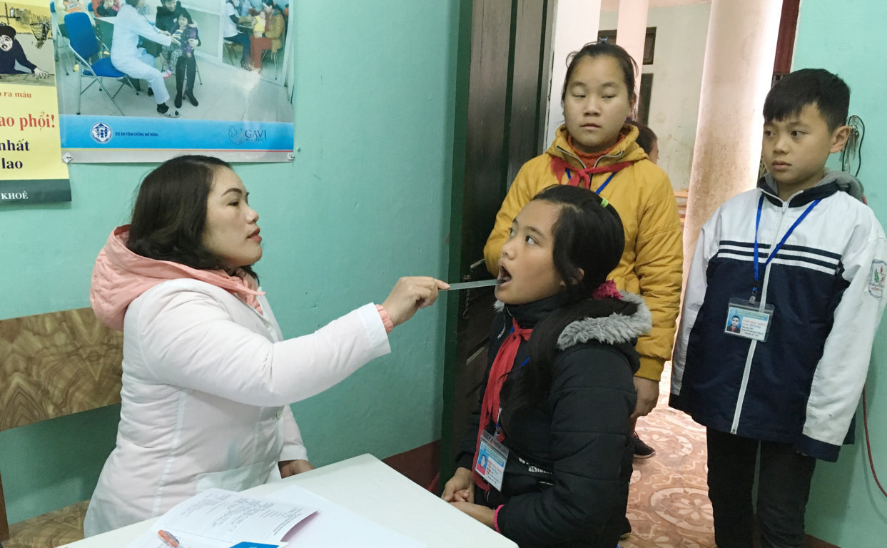 Các y, bác sĩ Trung tâm Y tế huyện khám sức khỏe cho các em học sinh tại Trường PTDT Nội trú huyện