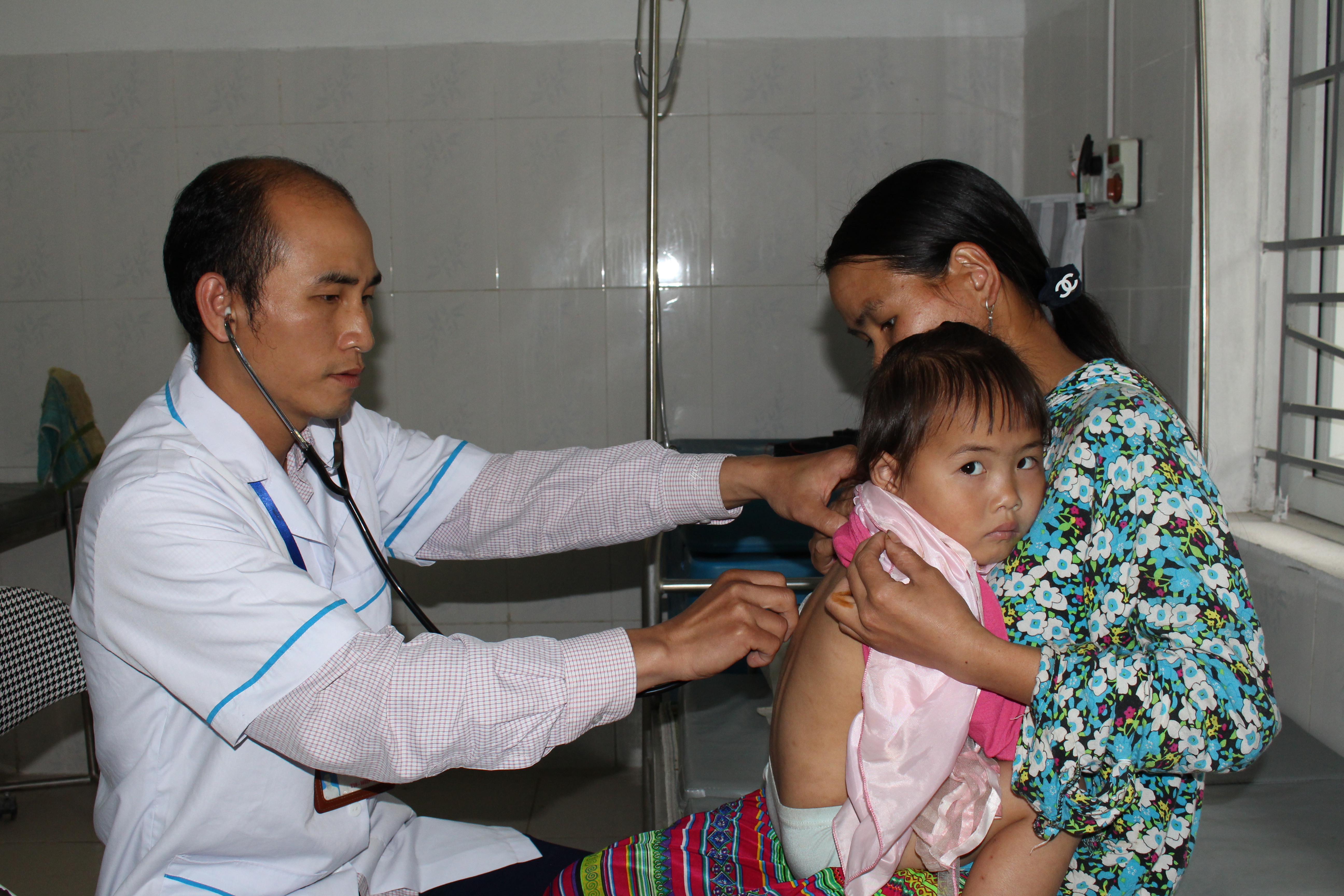 Y sỹ Nguyễn Văn Tiến trong một lần khám chữa bệnh cho trẻ em trên địa bàn