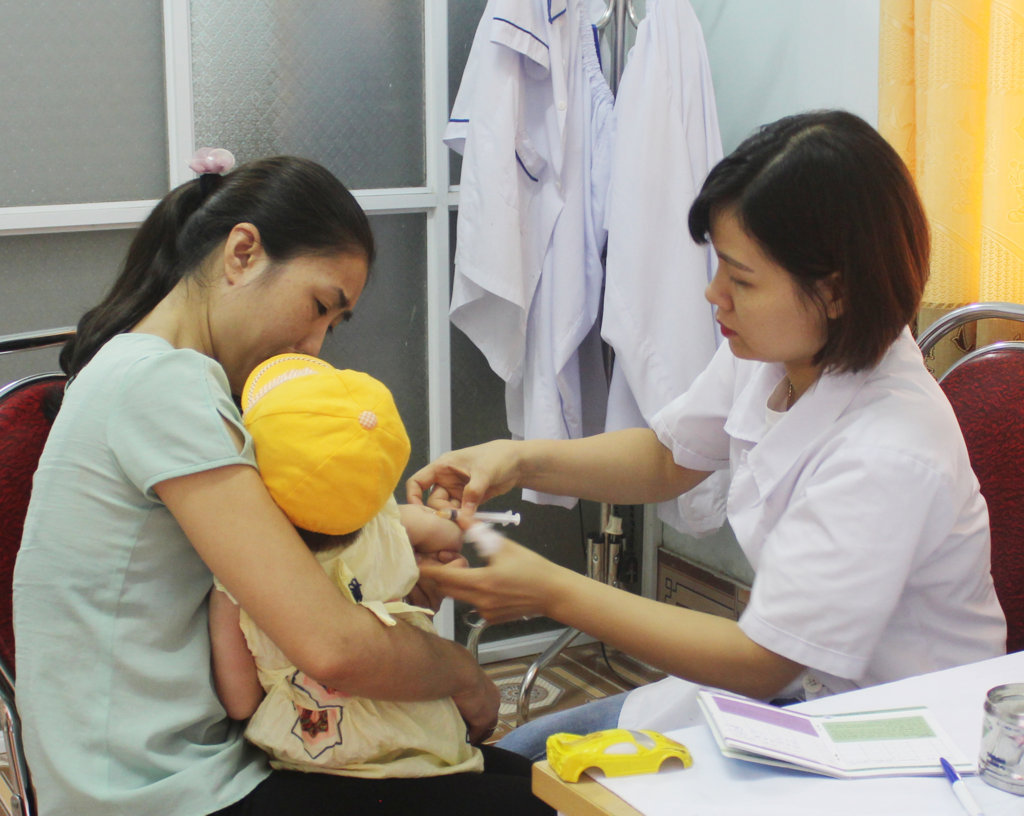 Cán bộ Trạm Y tế phường Nguyễn Trãi tiêm vắc xin phòng viêm não Nhật Bản cho trẻ