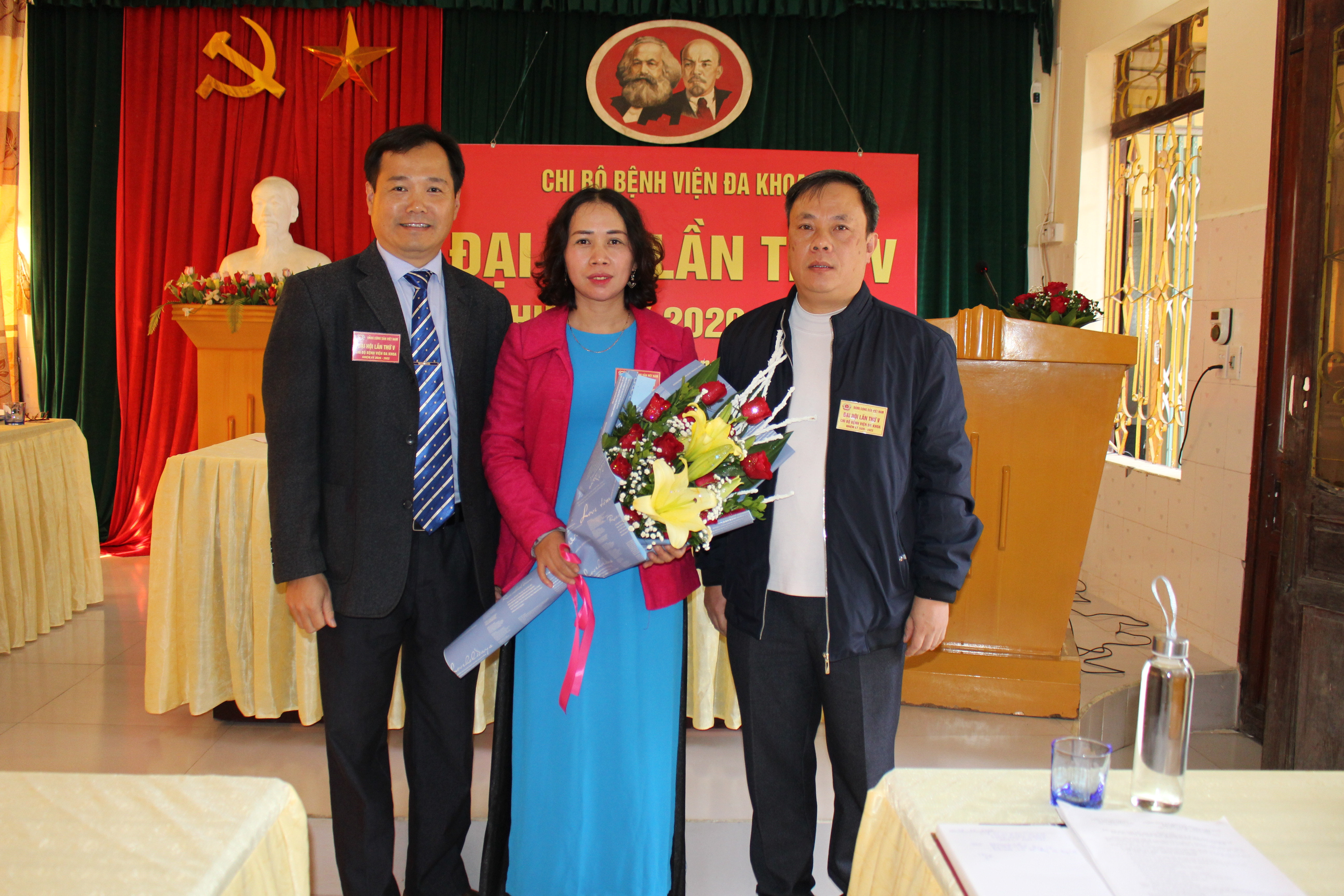 Đồng chí Dương Minh Sơn, Phó Bí thư Đảng ủy Y tế, Giám đốc Trung tâm DS-KHHGD huyện tặng hoa chúc mừng Ban Chi ủy Chi bộ Bệnh viện đa khoa huyện