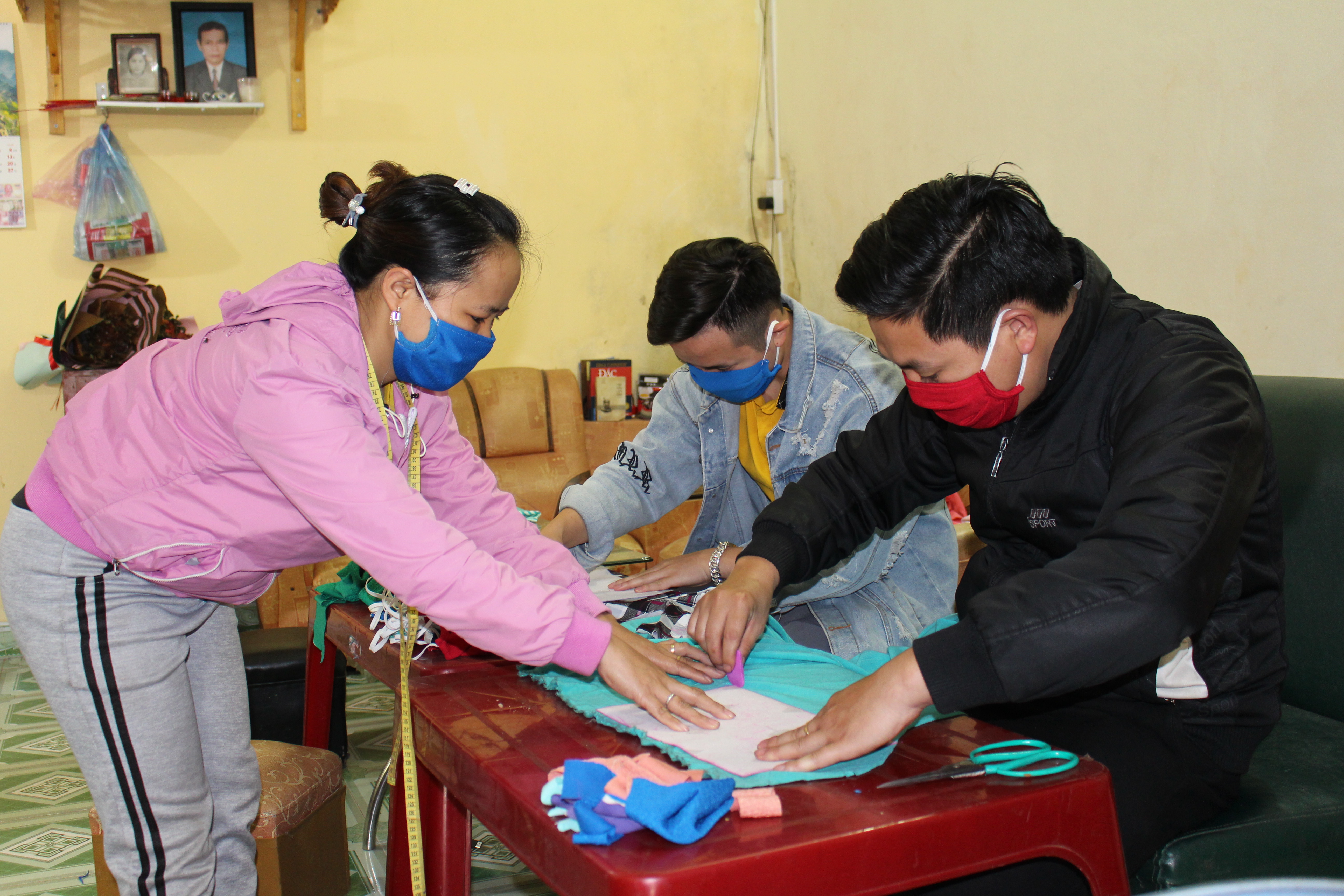 Chị Hoàn cùng các tình nguyện viên tiến hành cắt, đo khẩu trang vải
