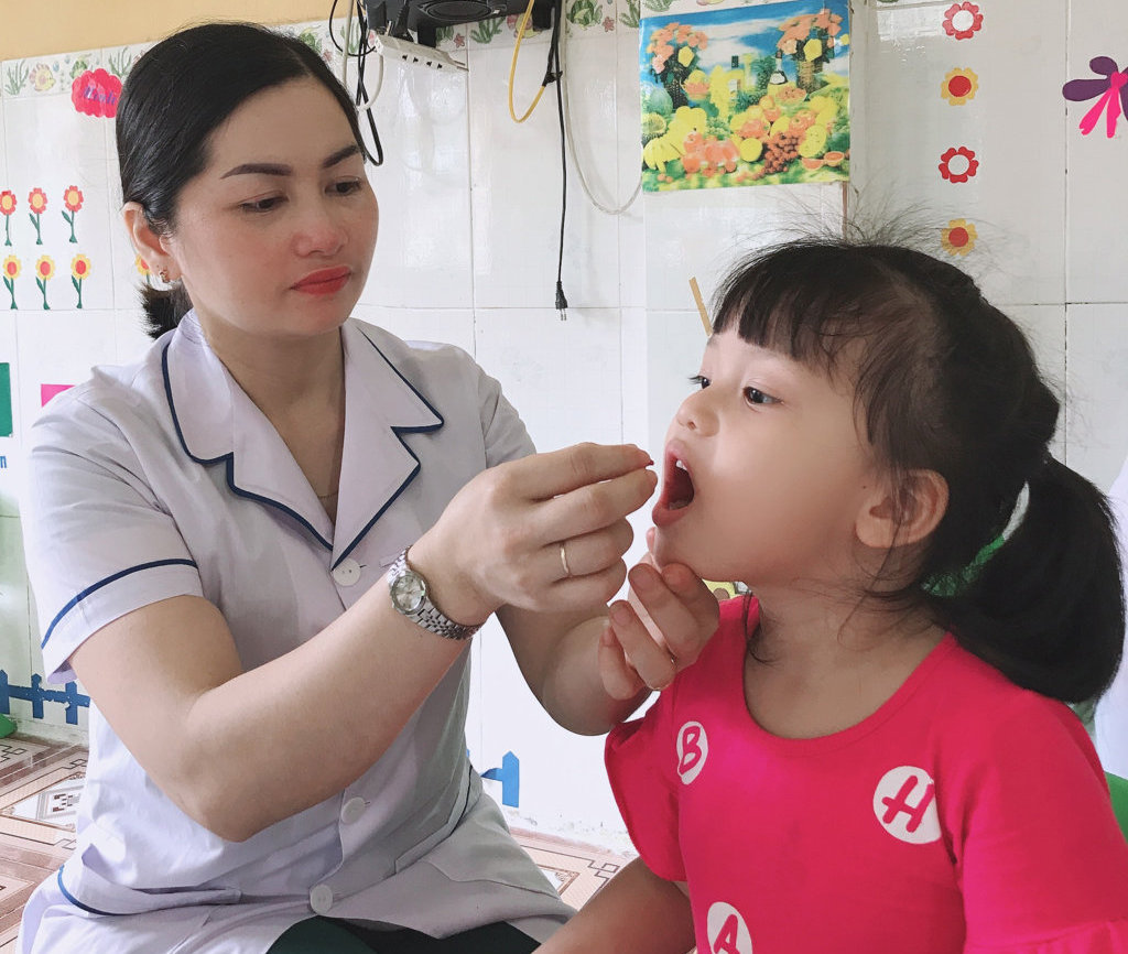 Cán bộ Trạm Y tế phường Minh Khai cho trẻ uống vitamin A tại Trường Mầm non Sao Mai