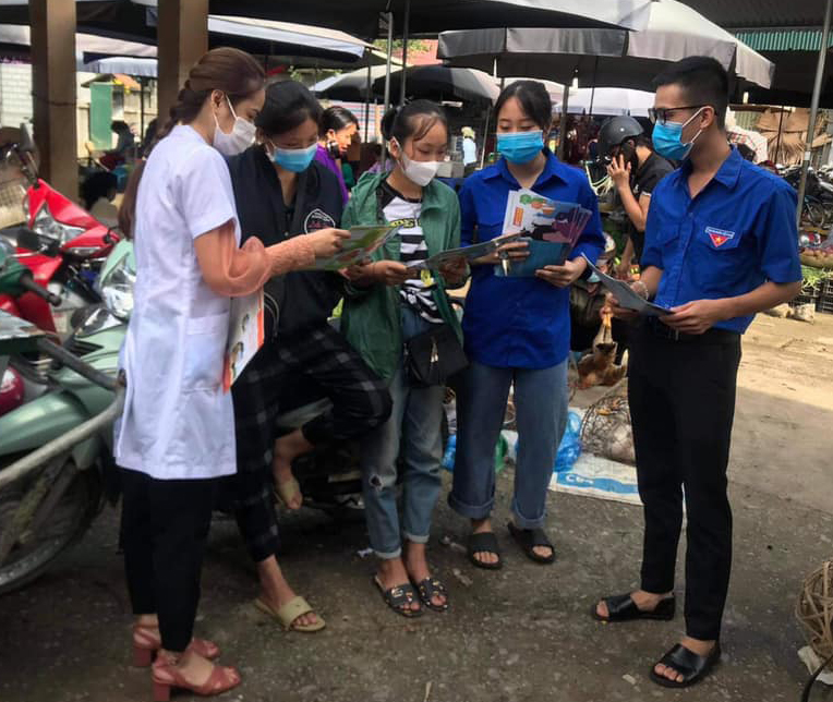 Cán bộ y tế và đoàn viên thanh niên phát tờ rơi tại chợ trung tâm thị trấn Yên Phú