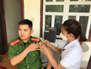 Cán bộ Trung tâm Y tế Quang Bình tiêm phòng vắc xin cúm cho cán bộ chiến sĩ công an huyện.