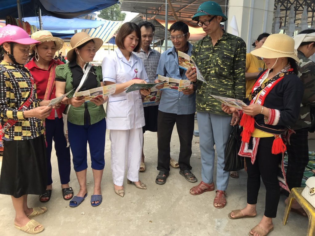 Cán bộ y tế phát tờ rơi, truyền thông phòng chống ngộ độc thực phẩm và phòng chống bệnh sốt xuất huyết tại chợ phiên xã Tân Nam, huyện Quang Bình